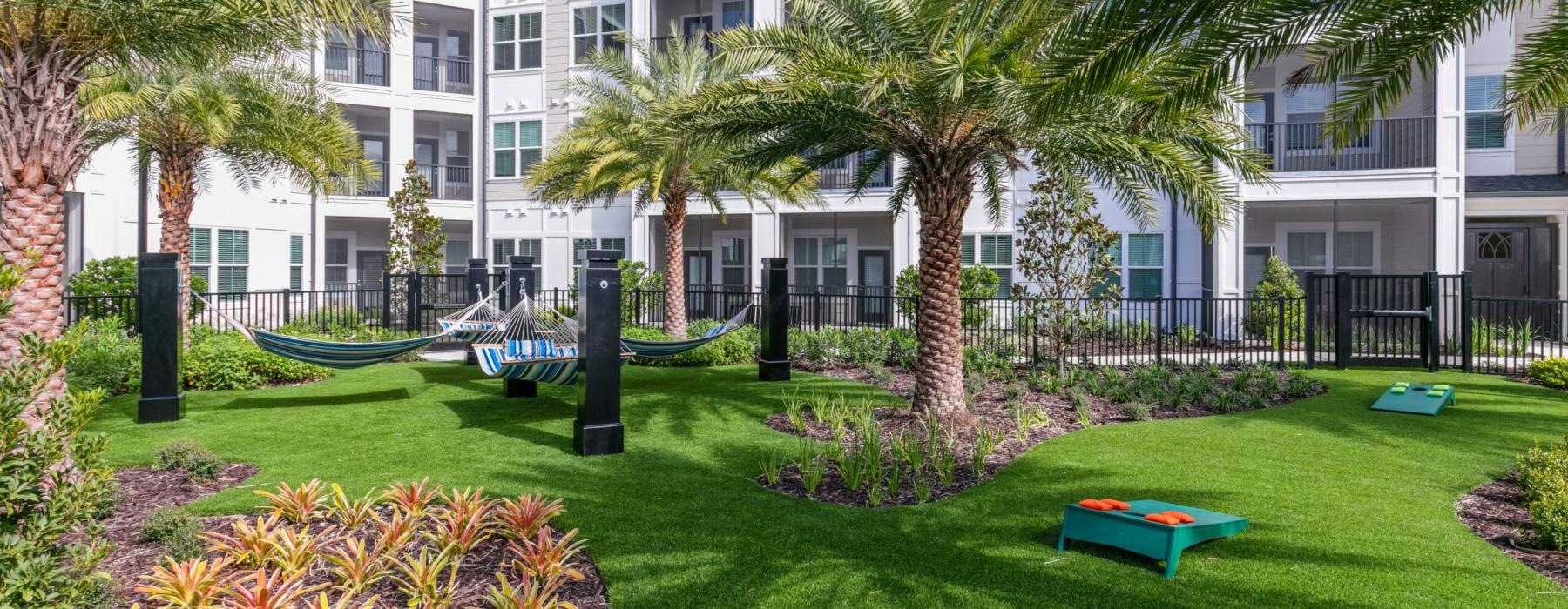 a park with hammocks in front of a building