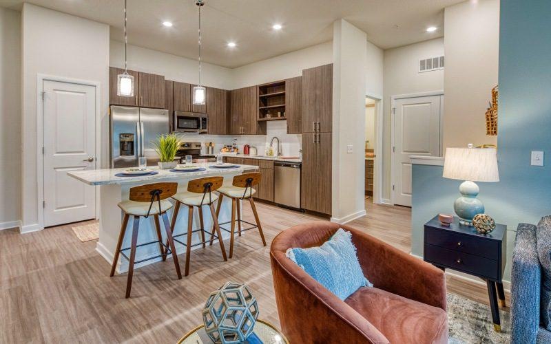 a kitchen with wooden cabinets and bar chairs